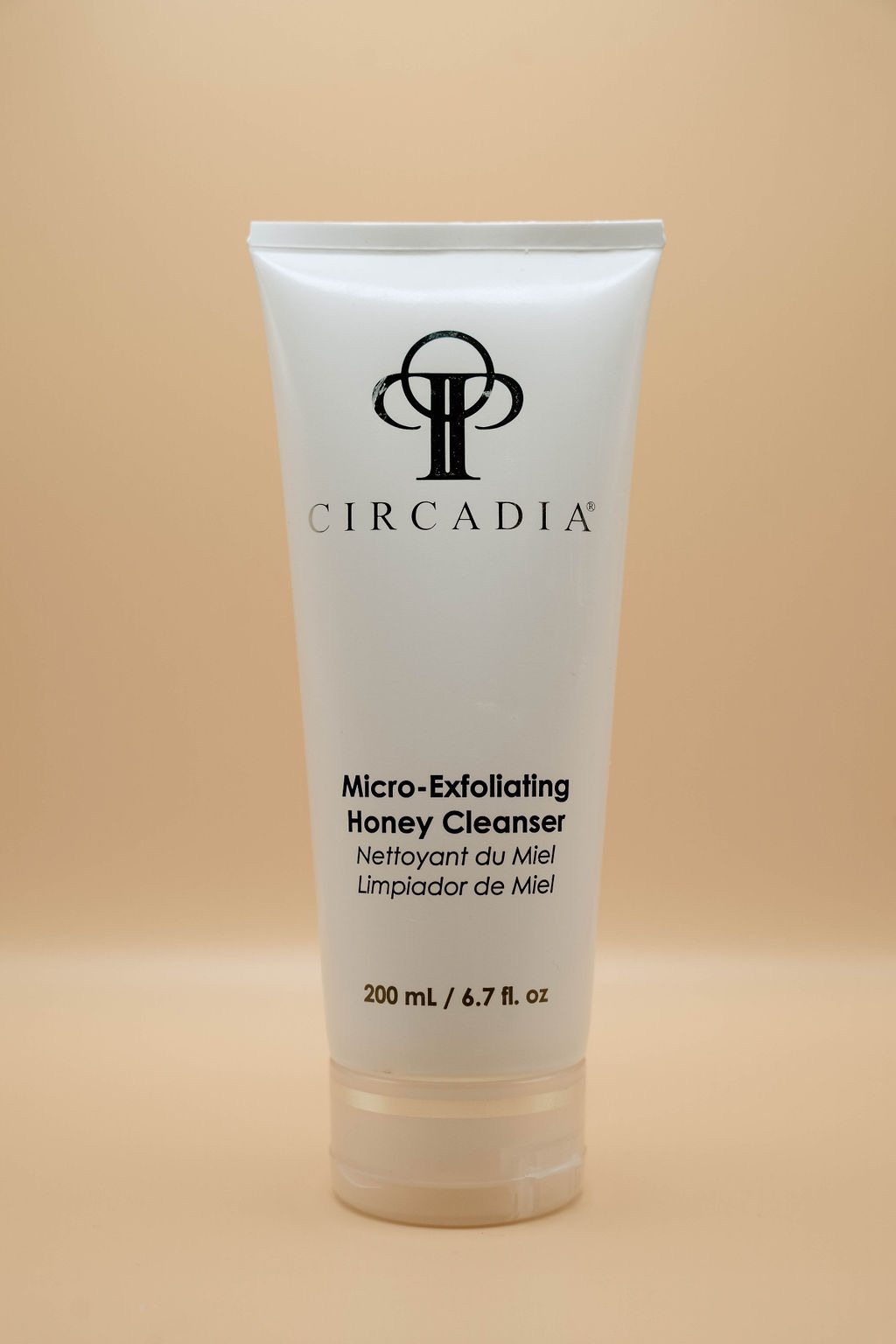 A tube of Circadia Micro-Exfoliating Honey Cleanser, 200 mL (6.7 fl. oz.), on a beige background.